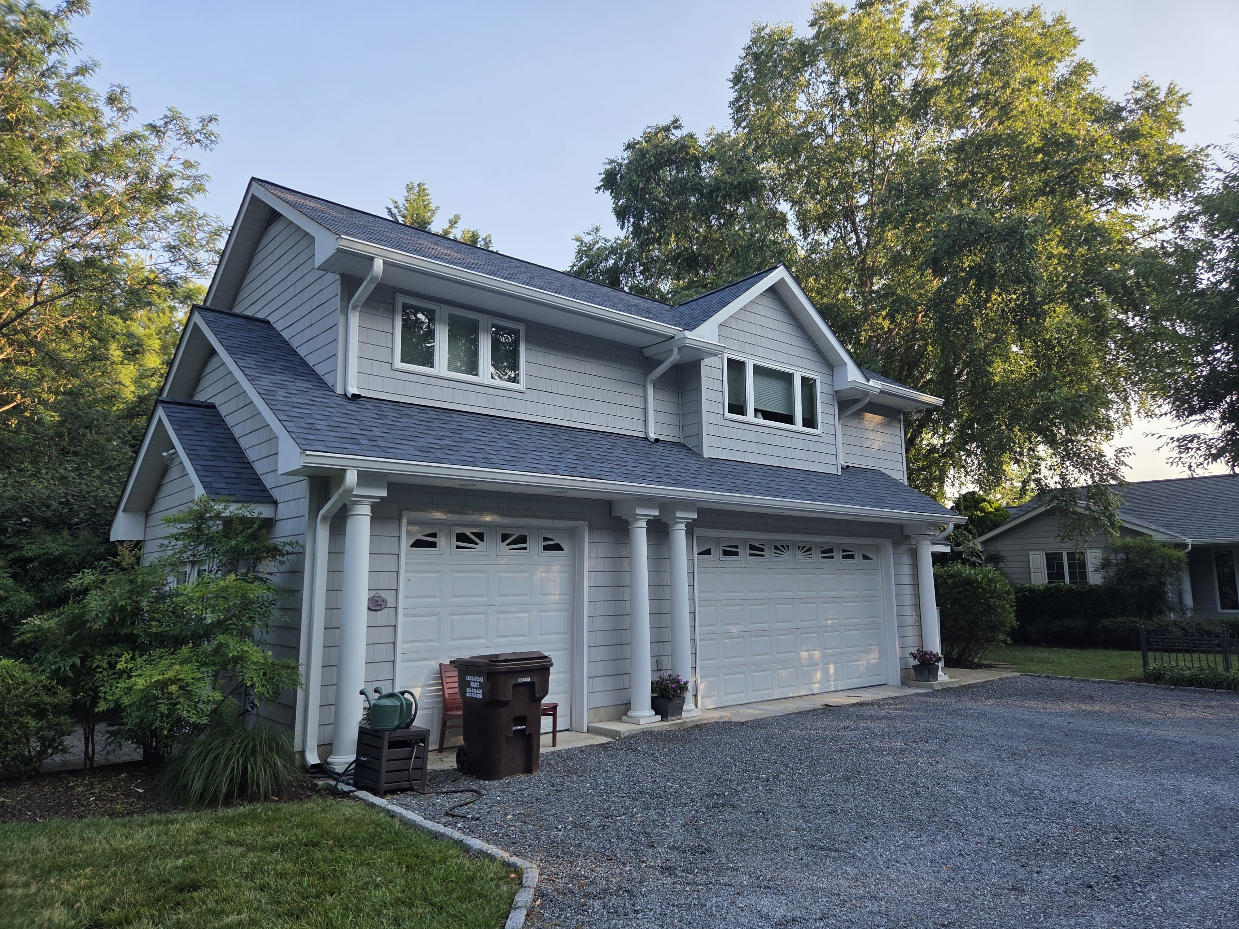 Detached garage with finished dark roof, light exterior siding, and white trim
