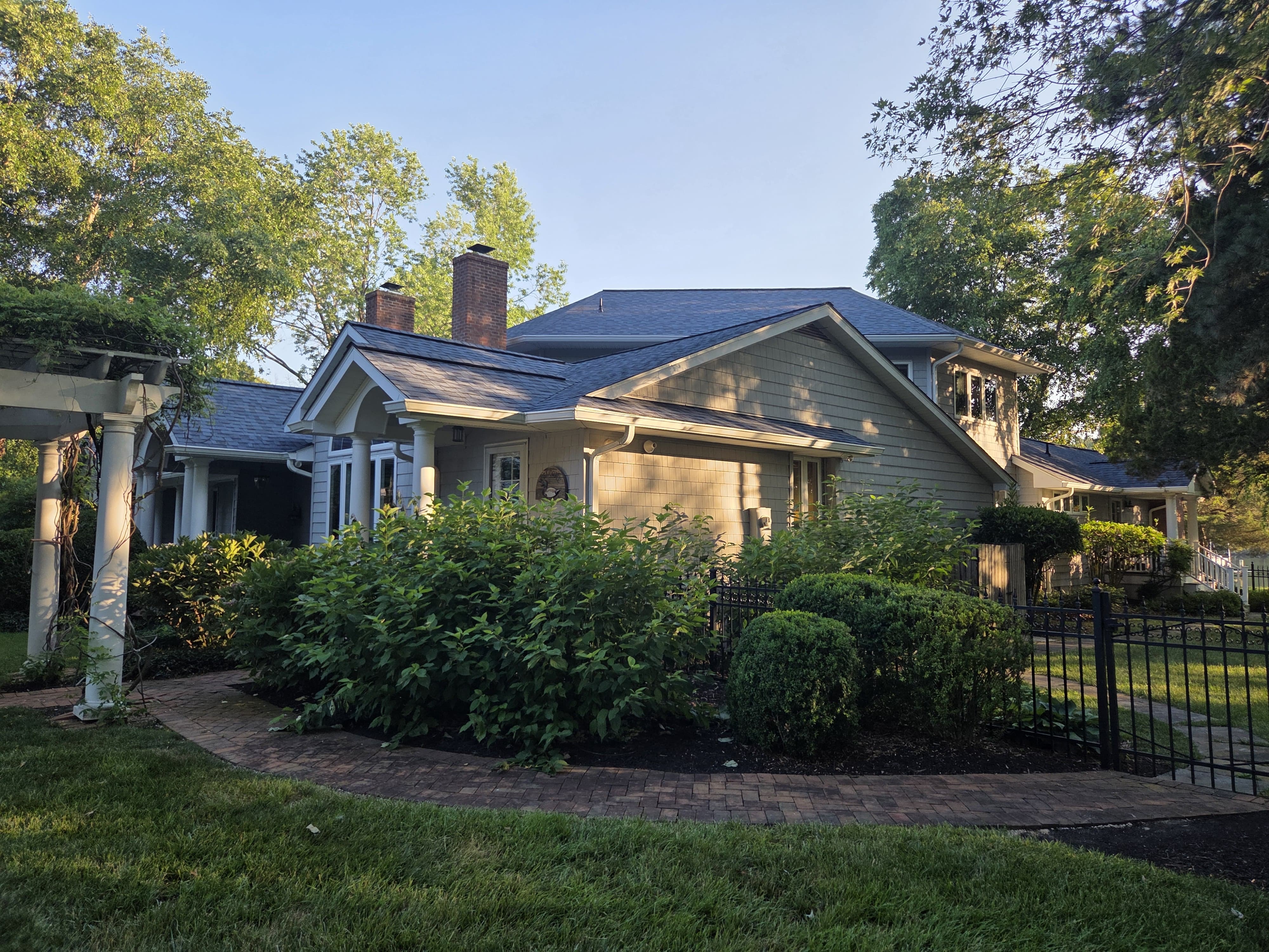 Side view of a residential home with completed roof replacement and fresh exterior details